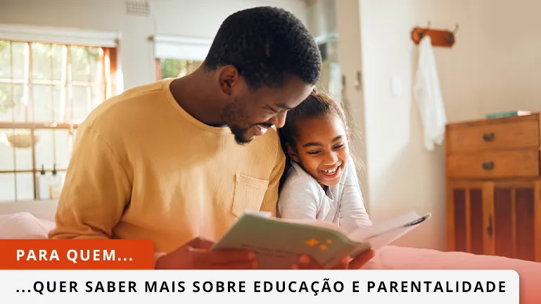 Pai a ler um livro ao filho, com ele aninhado ao colo.