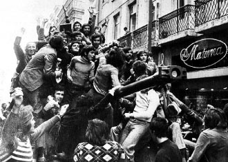 Fotografia da revolução, com vários populares em cima de umm tanque de guerra.