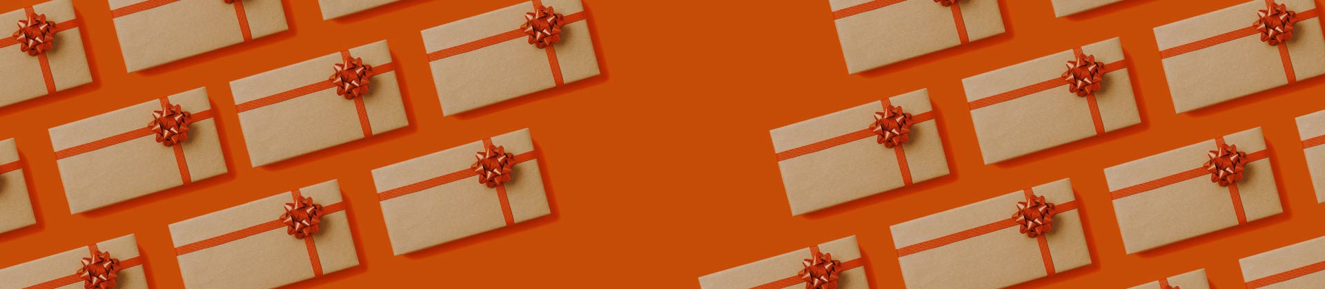 Conjunto de caixas presente de natal embrulhadas e com laços laranja.