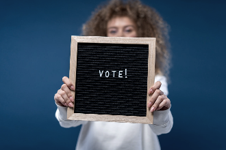 Mulher a segurar cartaz a dizer 